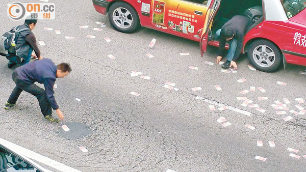 ■鈔票散布一地,有人索性落車執錢。(讀者提供)